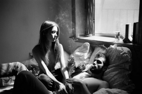 black and white couple in bed smoking