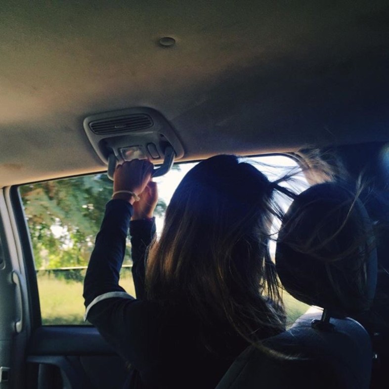 girl holding onto car